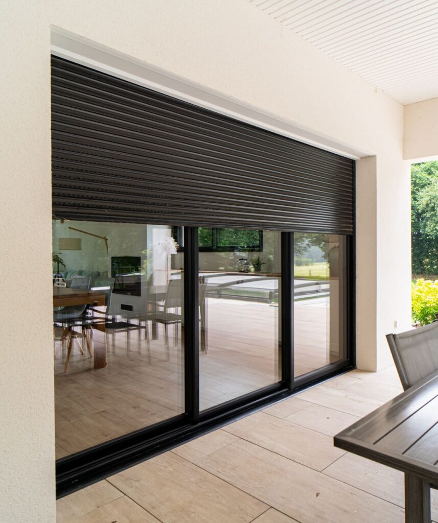 Empreinte® : baie vitrée, 3 vantaux et volets roulants Pasquet menuiseries – Noir RAL 9005 ext et int
