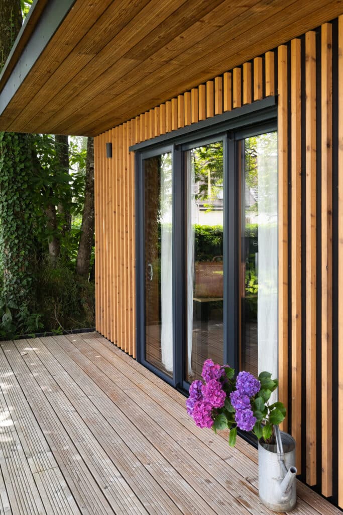 Auralu® : baie vitrée 3 vantaux – Gris RAL 7016 ext et moabi lasuré int