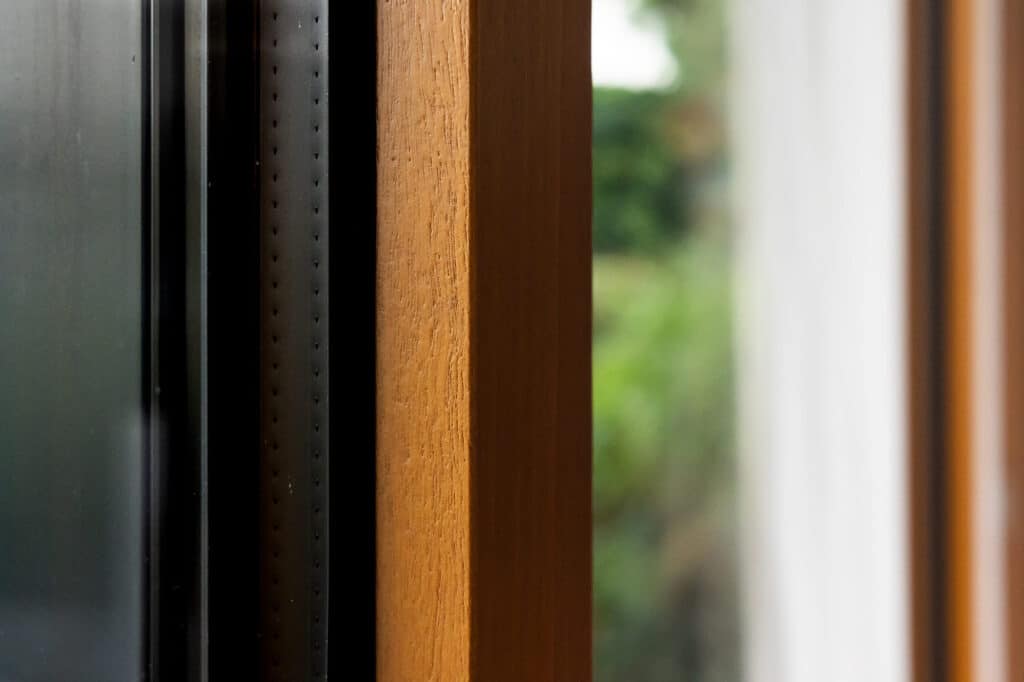 Auralu® : baie vitrée 3 vantaux – Gris RAL 7016 ext et moabi lasuré int